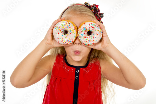 little female child happy playing with two sugar donuts as her eyes