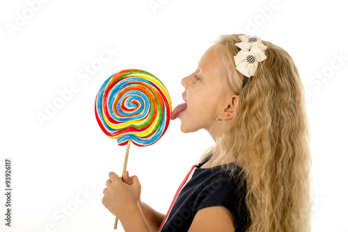 Foto beautiful female child with long blond hair eating licking huge spiral lollipop