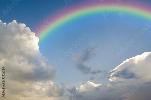 Clear blue sky with white cloud and rainbow