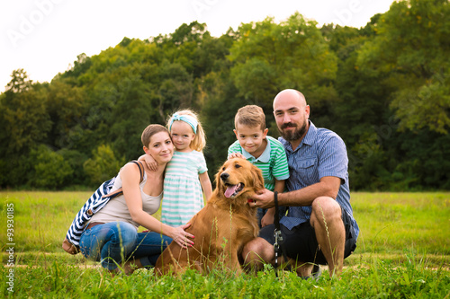 Beautiful young family with their pet dog, golden retriever