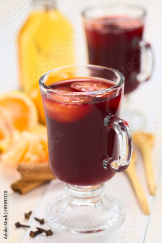 Hot spiced mulled red  wine with mandarin on top (Selective Focus, Focus on the front of the rim and the handle of the glass)