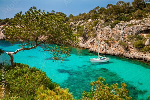 the yacht in azure sea in the village Cala Pi photo
