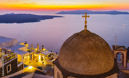 Santorini at night with twilight sky above Mediterranean sea, Greece (selective focus on cross at top of church)