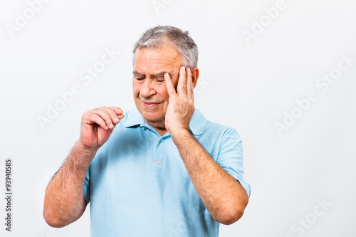 Senior man taking pills for headache