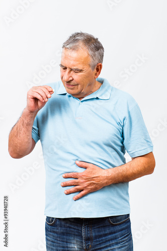 Senior man taking pills for stomachache © inesbazdar