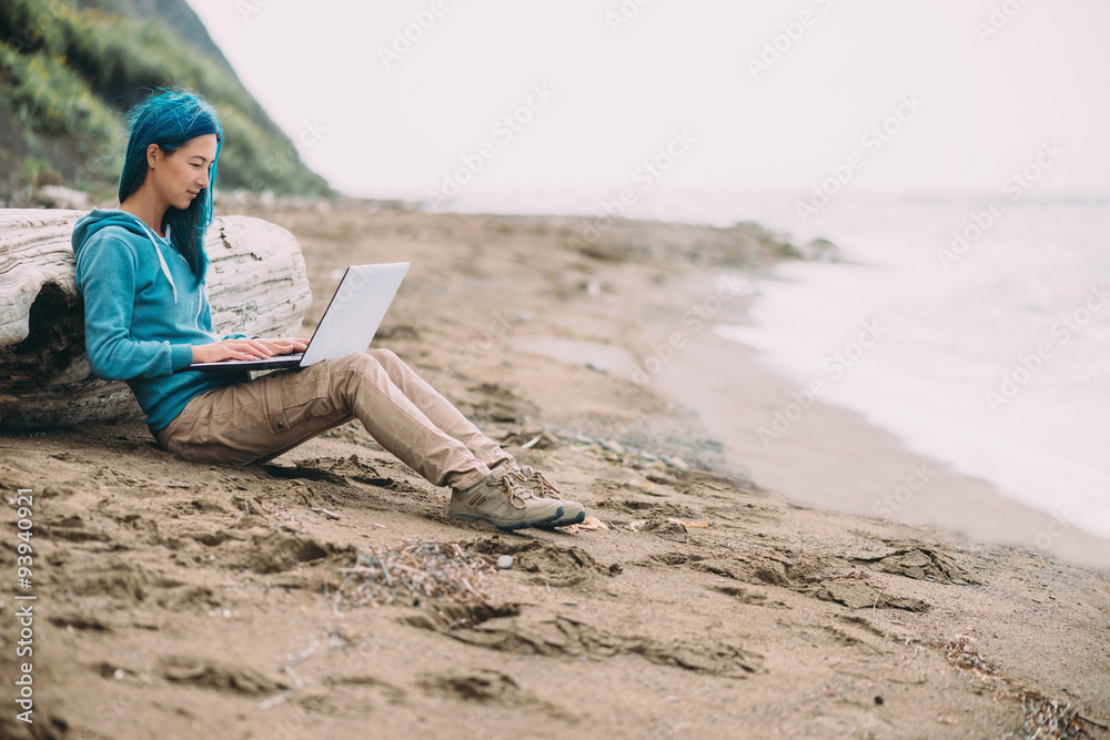 Freelancer girl working on laptop on beach