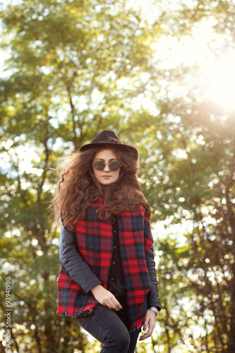 девушка в шляпе гуляет в осеннюю солнечную погоду