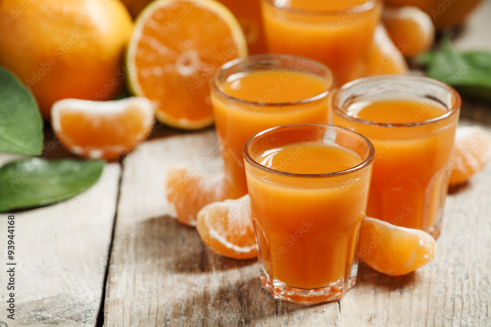 Fresh tangerine juice with slices of mandarin on old wooden back Fresh tangerine juice with slices of mandarin on old wooden back