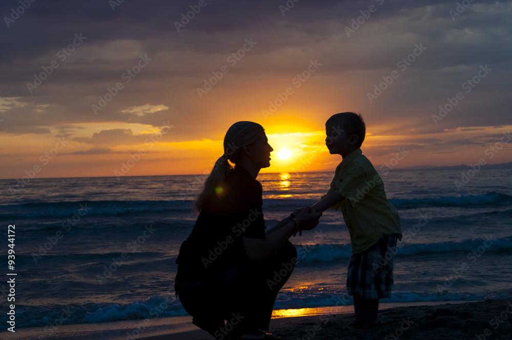 Mother and son and a beautiful sunset over the sea