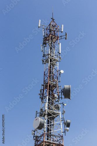 communications tower with antennas against blue sky