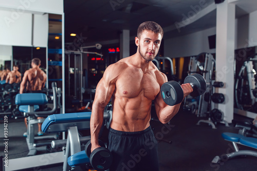 Very power athletic guy bodybuilder , execute exercise with dumbbells