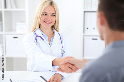 Doctor and patient handshaking in hospital office
