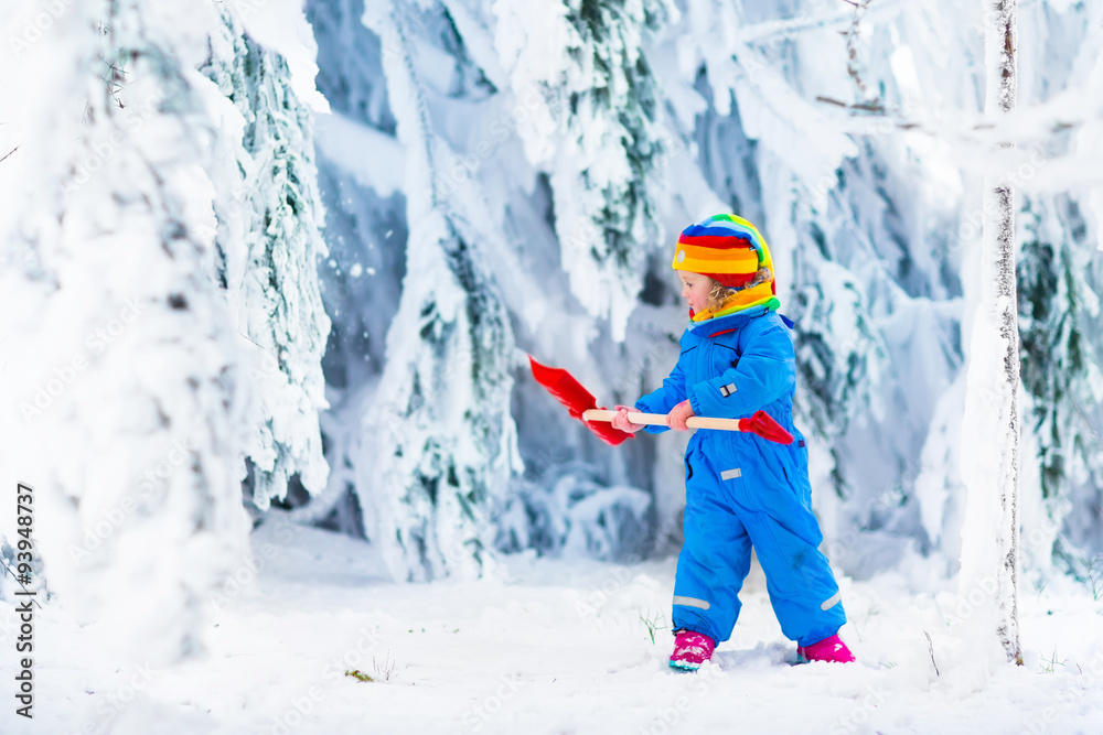 Little girl playing with snow in winter