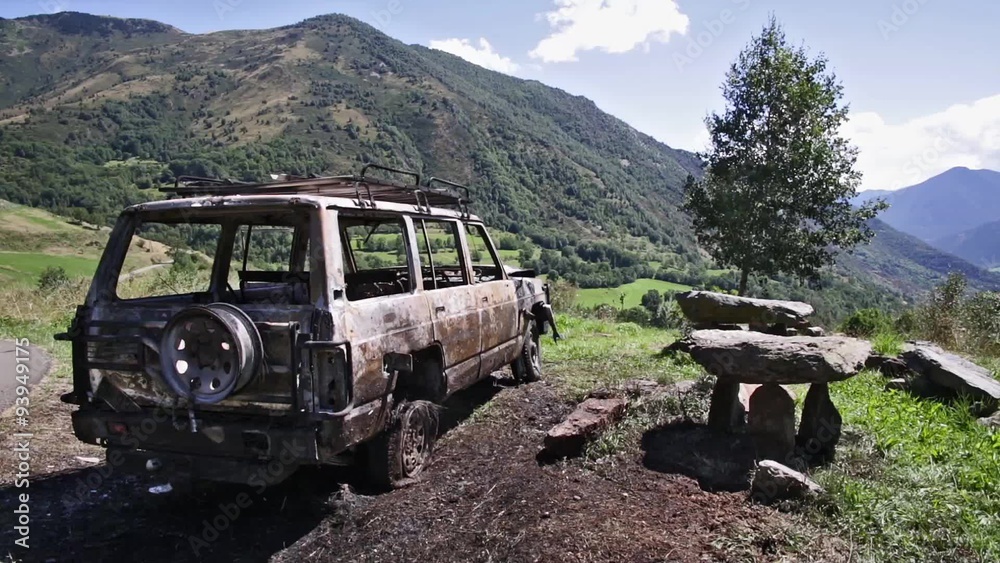 Car that has burned in the middle of nature and becomes a beautiful landscape in a desolate place.
