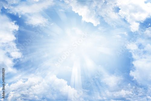 Foto Rays of light shining in blue sky clouds
