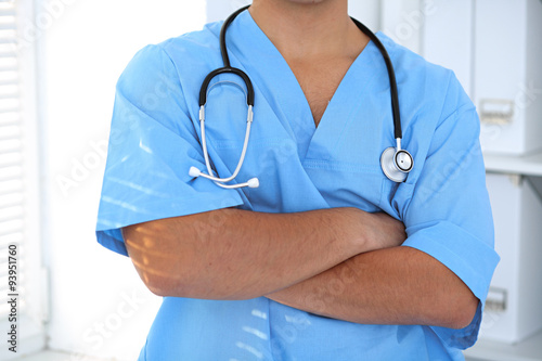 Portrait of unknown male surgeon doctor holding his stethoscope, crossed arms