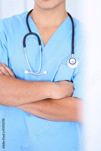 Unknown surgeon with stethoscope, crossed arms