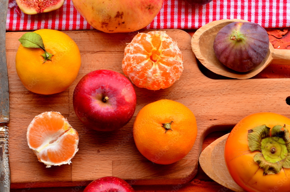 Figs, persimmon, pomegranate, apples and mandarines (tangerines) on rough background Figs, persimmon, pomegranate, apples and mandarines (tangerines) on rough background