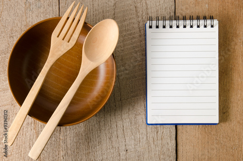 Blank note book with wooden spoon on tabletop