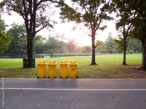 the yellow litter bin in a park