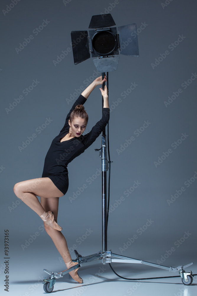 Naklejka premium The beautiful ballerina posing on dack blue background 