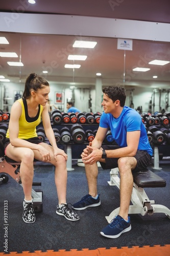Fit couple chatting in weights room