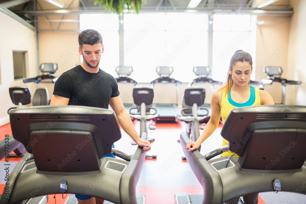 Man and woman using treadmills Man and woman using treadmills