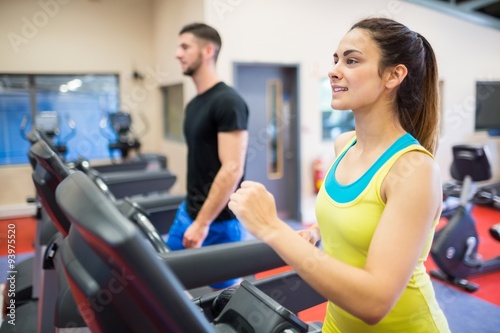 Smiling woman running on a treadmill