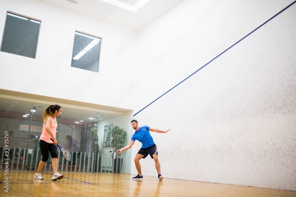 Couple playing a game of squash Couple playing a game of squash