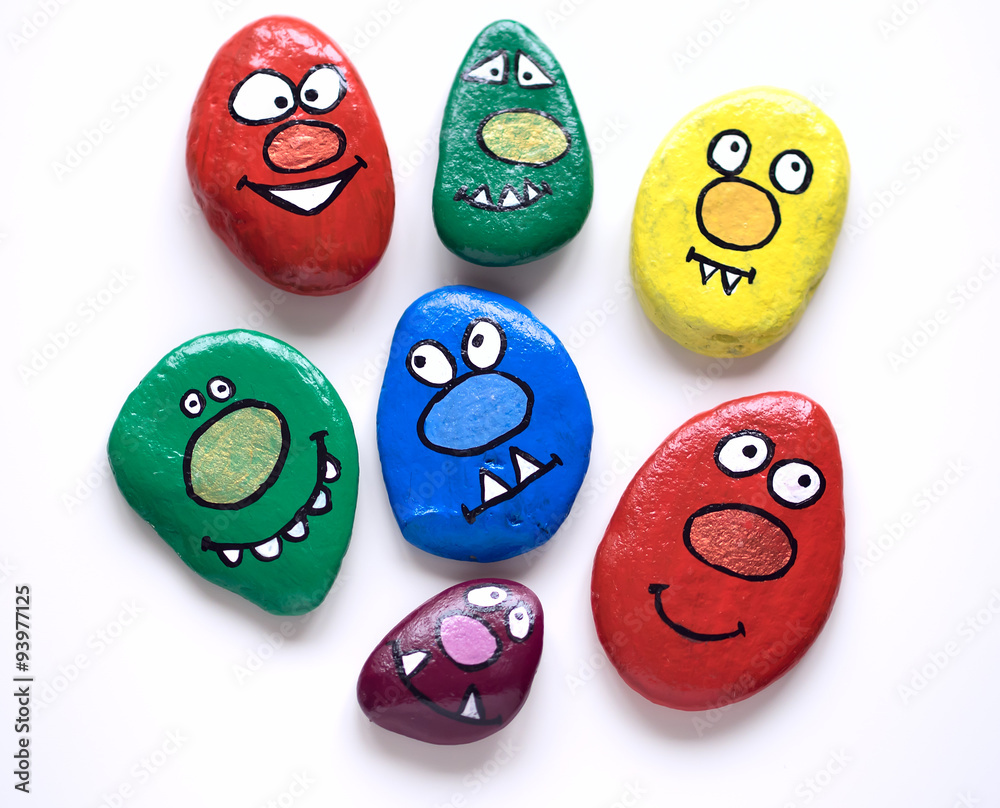 Fototapeta premium Seven smiling faces of monsters. Painted acrylic pebbles.