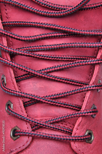 Binding laces in the shoe with a red leather closeup