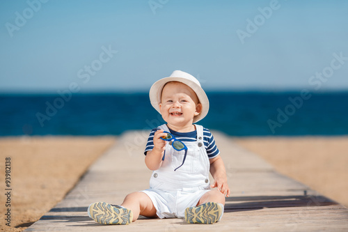 Portrait of a happy child with a hat on the beach