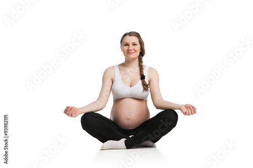 Pregnant woman relax doing yoga, sitting in lotus position 
