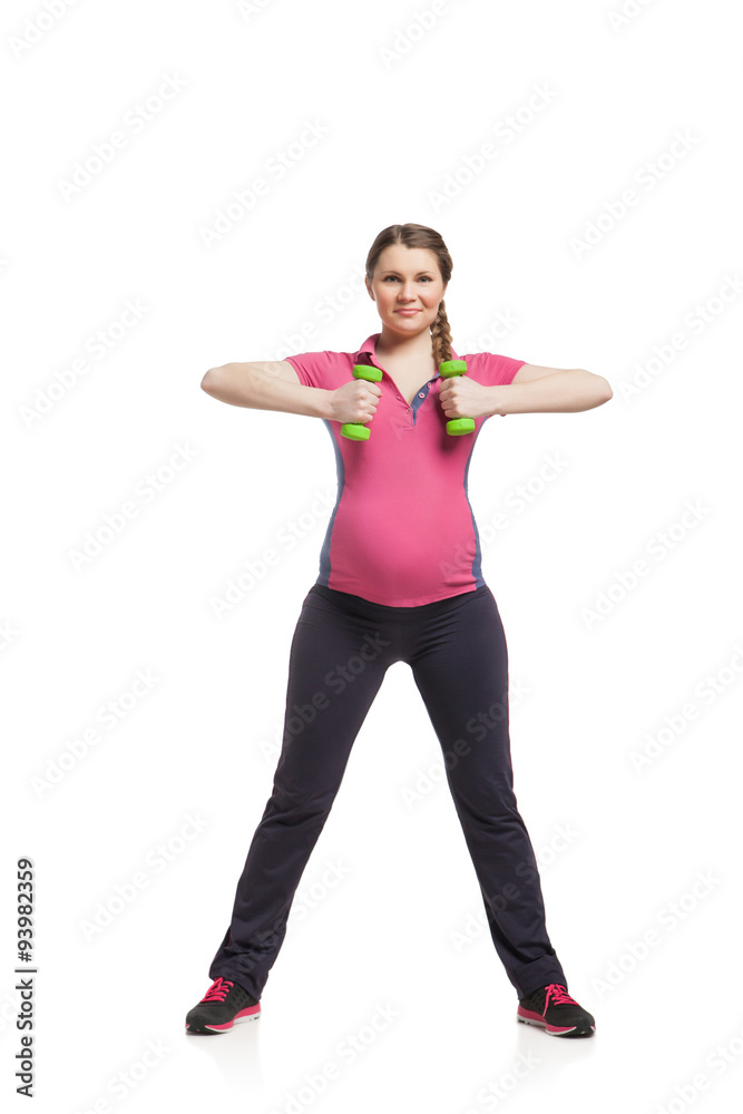 Young pregnant woman making exercise with dumb bells Young pregnant woman making exercise with dumb bells