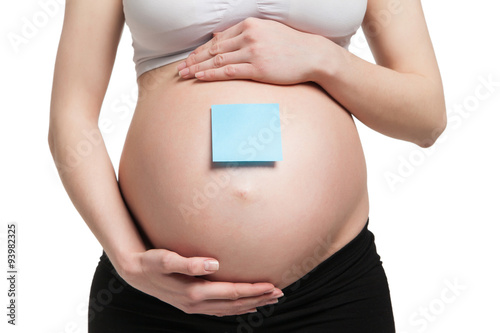 Pregnant woman holding belly with arms 