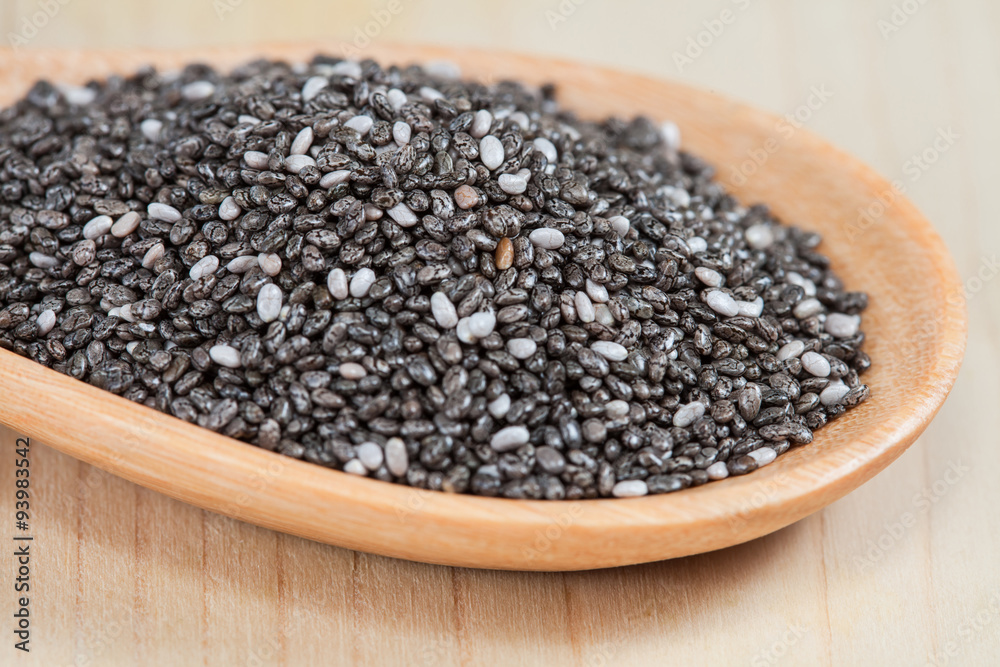 chia seeds in a wooden scoop on wood cup chia seeds in a wooden scoop on wood cup