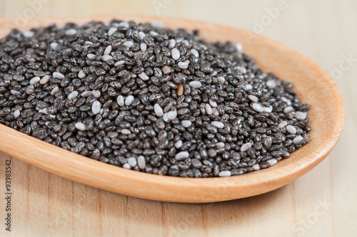 chia seeds in a wooden scoop on wood cup
