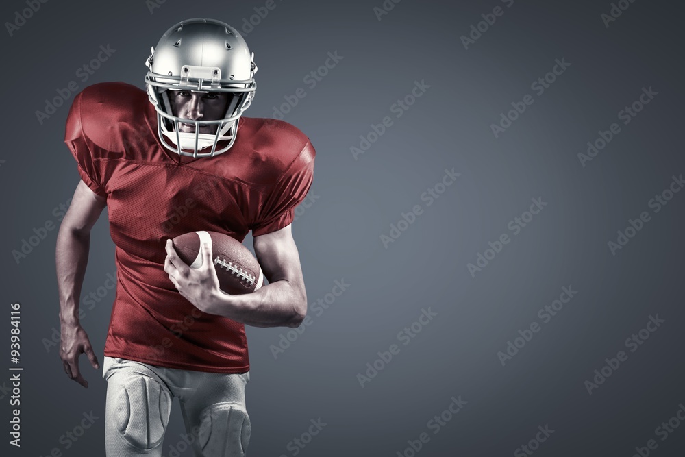American football player running while holding ball