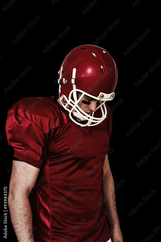 Composite image of american football player looking down