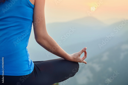 Woman meditating in the nature on sunset