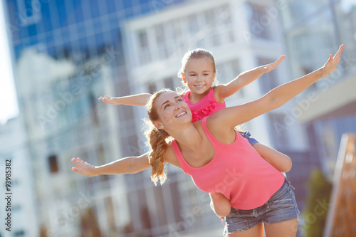 Happy mother and her daughter playing outdoors in summer.
