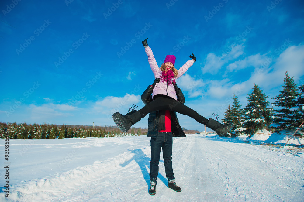 Young beautiful couple in bright clothes winter fun in the snow, lifestyle, winter holidays
