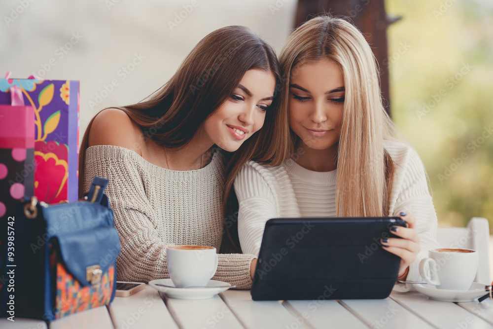 Girlfriends consider photos on the digital tablet Girlfriends consider photos on the digital tablet