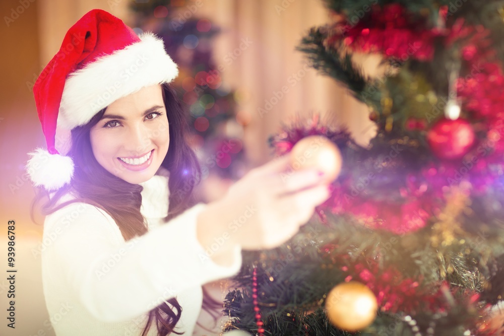Festive brunette decorating a christmas tree Festive brunette decorating a christmas tree