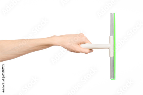Household cleaning and washing windows theme: man's hand holding a green scraper windows isolated on a white background in the studio.