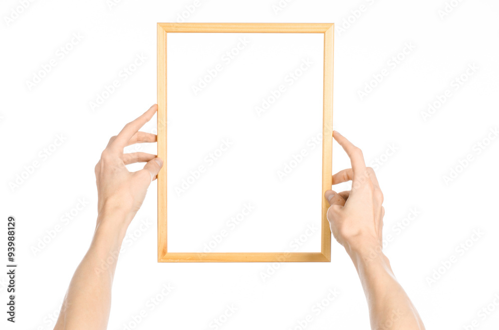 House decoration and Photo Frame topic: human hand holding a wooden picture frame isolated on a white background in the studio first-person view House decoration and Photo Frame topic: human hand holding a wooden picture frame isolated on a white background in the studio first-person view