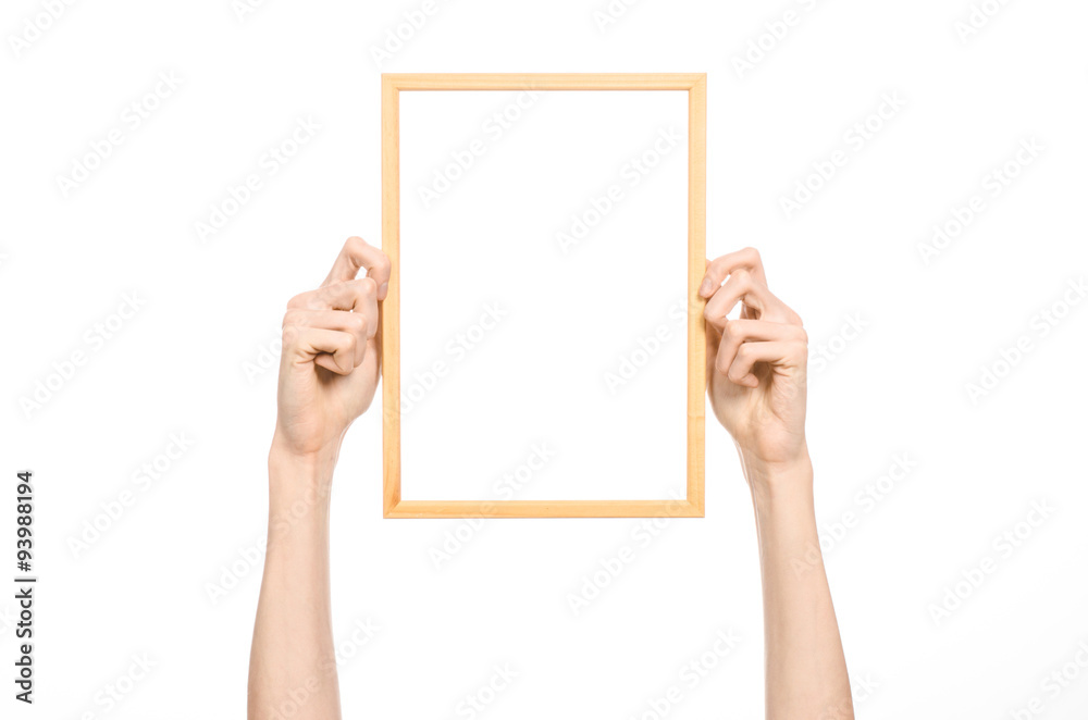 House decoration and Photo Frame topic: human hand holding a wooden picture frame isolated on a white background in studio