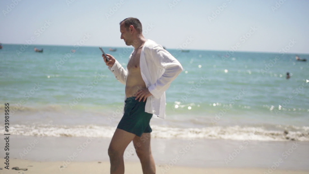 Young man using smartphone and walking on beach, slow motion 240fps
Young man using smartphone and walking on beach, slow motion 240fps