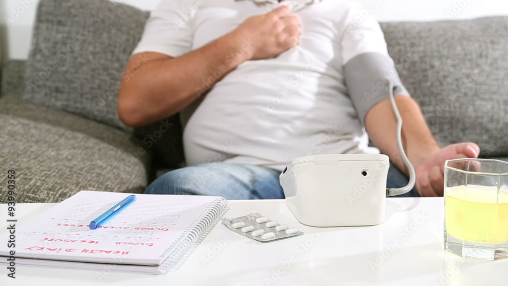 Man measuring blood pressure at home, having chest pain. Man measuring blood pressure at home, having chest pain.