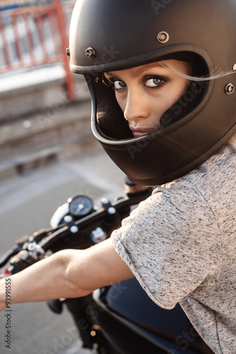 Biker girl sitting on vintage custom motorcycle photo